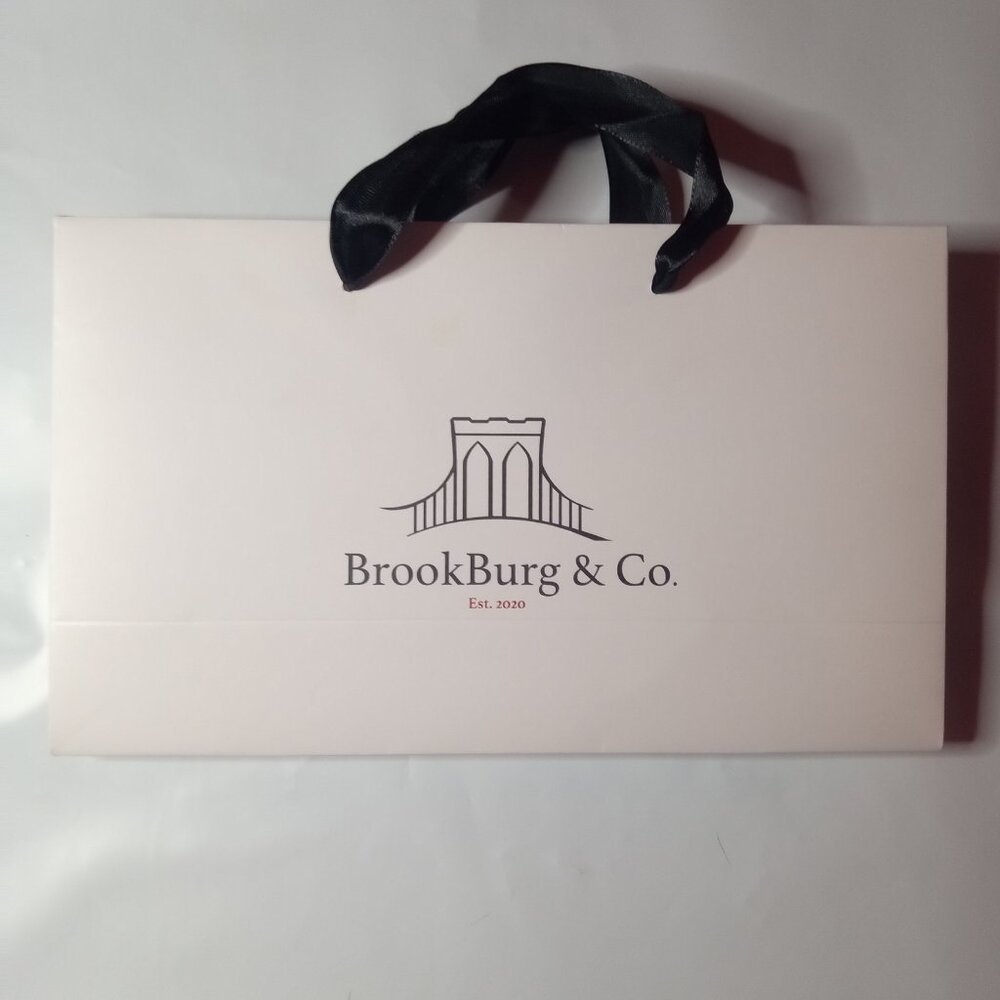 BrookBurg & Co white merchandise bag with black handles